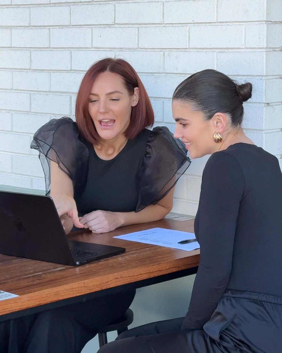 Renee and one of her stylists working together over coffee
