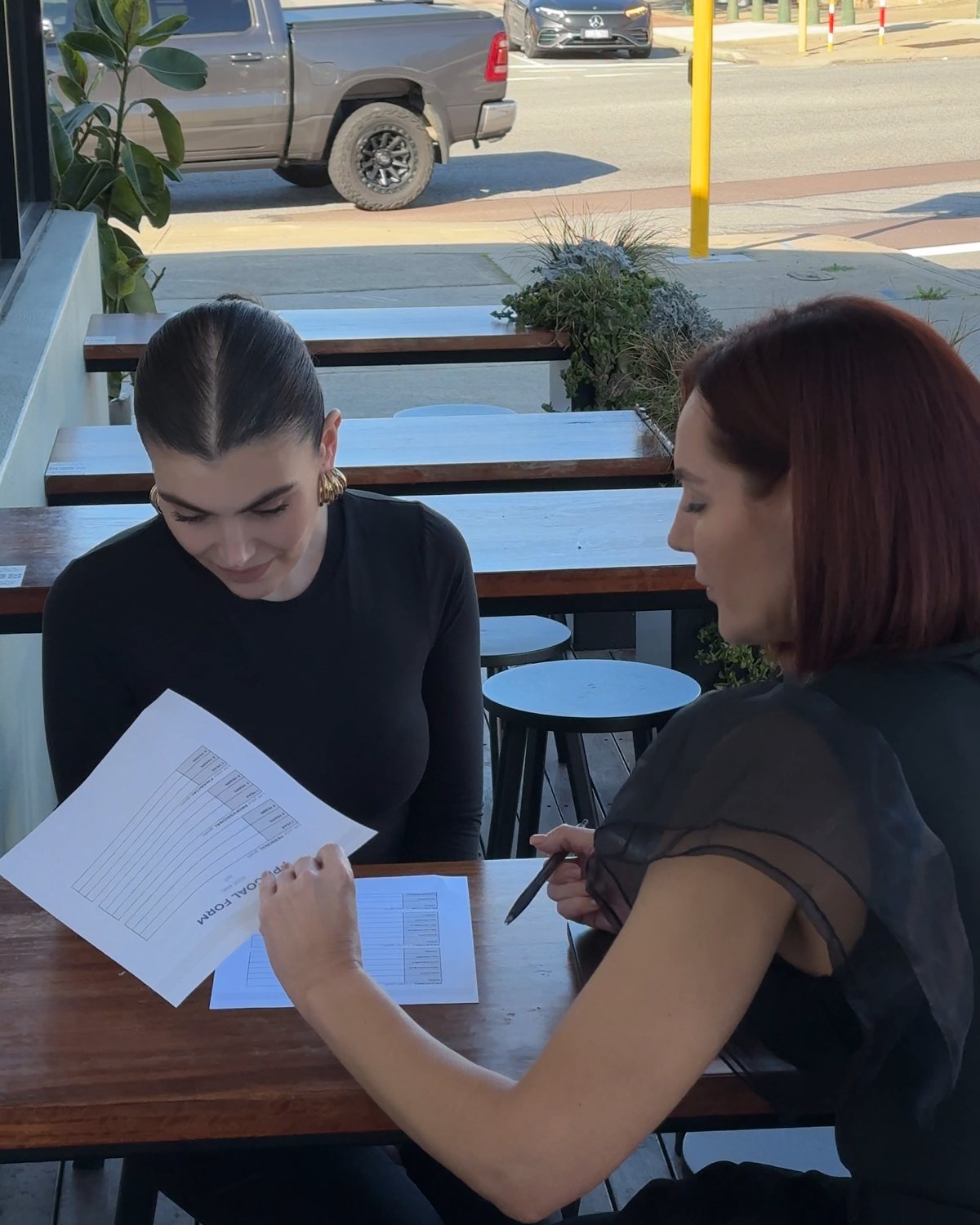 Renee and a stylist going through her goals at an outdoor table